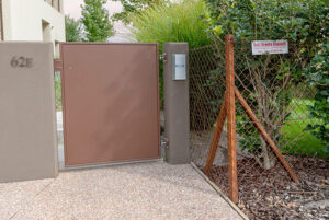 Cancello pedonale in lamiera cieca color Corten installato presso un residence