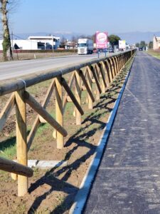 Staccionata in legno a croce di Sant’Andrea installata lungo una pista ciclabile