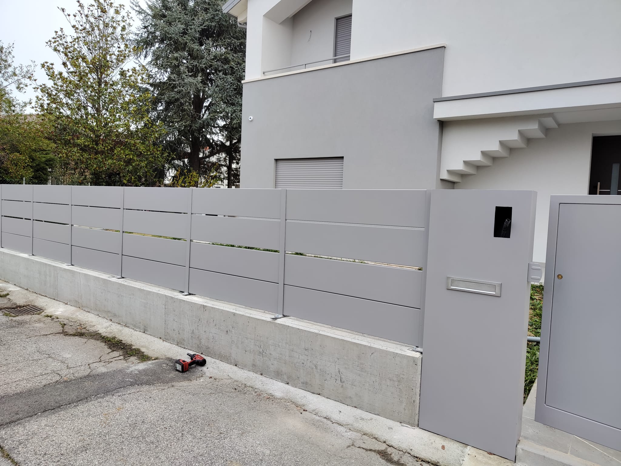 Testo alternativo dell’immagine Recinzione grigia a doghe orizzontali con cancello pedonale coordinato